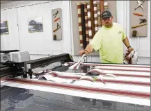  ?? STAFF FILE ?? Shaun Fridley, grandson of Glawe’s CEO Vernon Schaefer, operates a digital fabric cutter that saves hours of manual cutting time for custom awnings and tents.