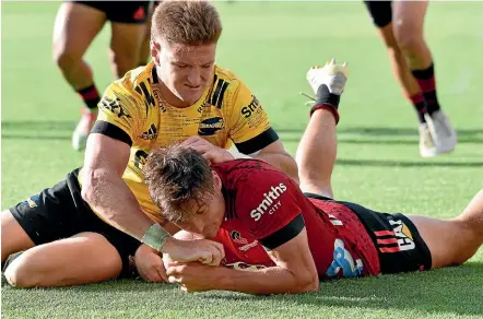  ?? GETTY IMAGES ?? Hurricanes fullback Jordie Barret fails to stop George Bridge from scoring one of his two tries during the Crusaders 30-27 win in Wellington yesterday.