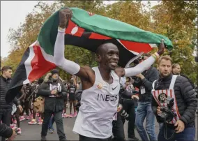  ?? JED LEICESTER - THE ASSOCIATED PRESS ?? Eliud Kipchoge celebrates with the Kenyan flag after breaking the historic two hour barrier for a marathon in Vienna, Saturday, Oct. 12, 2019.