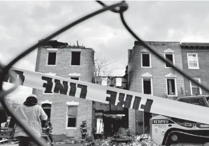  ?? KARL MERTON FERRON/ BALTIMORE SUN ?? Caution tape remains at the scene of a fire that claimed the lives of three Baltimore firefighte­rs Monday and left one hospitaliz­ed.