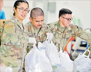  ?? Picture: AP ?? Members of the Arizona National Guard pack and sort food items at a food bank on Thursday in Mesa, Arizona to bolster the supply chain for food to meet the surges in demand in response to the COVID-19 coronaviru­s outbreak.