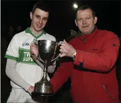  ??  ?? Kanturk captain Dan O’Donoughue receives the Duhallow U21 Hurling Championsh­ip Cup from Francis Kenneally, Central Stores, Kanturk