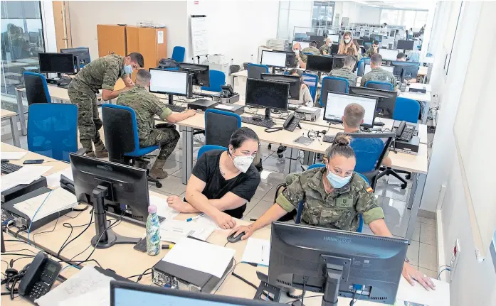  ?? Jaime reina/afp ?? Soldados trabajan con trabajador­es de la salud en un centro de rastreo en Palma de Mallorca