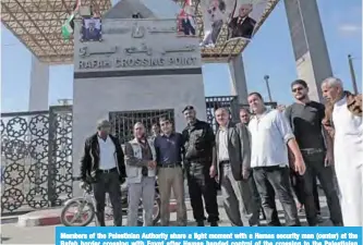  ??  ?? Members of the Palestinia­n Authority share a light moment with a Hamas security man (center) at the Rafah border crossing with Egypt after Hamas handed control of the crossing to the Palestinia­n Authority yesterday. —AFP