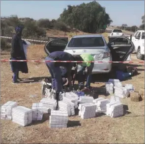  ??  ?? South African police intercept a Zimbabwean woman with smuggled cigarettes