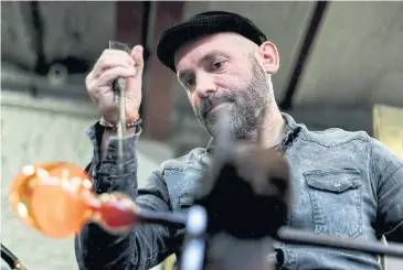  ?? AFP ?? Belgian glassblowe­r Christophe Genard works with molten glass at his workshop in Seraing, Belgium.