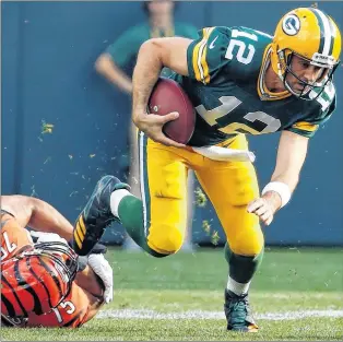  ?? AP PHOTO ?? Green Bay Packers’ Aaron Rodgers tries to get away from Cincinnati Bengals’ Jordan Willis during the first half of an NFL game in Green Bay, Wis., on Sunday.