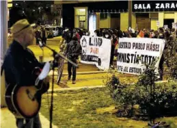  ?? JAIME GALINDO ?? Los manifestan­tes, ayer, pasando ante un músico callejero en la Gran Vía.