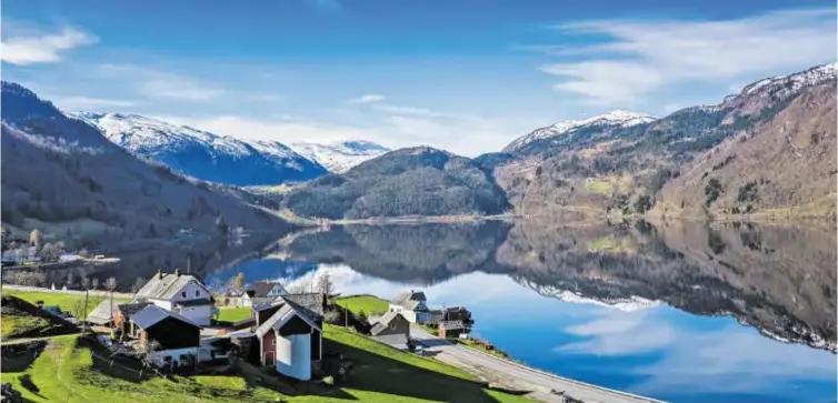  ??  ?? Norwegen von seiner Sonnenseit­e: spiegelgla­tte Wasserfläc­he im Fjord.