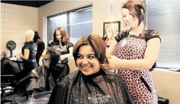  ?? Pin Lim / For the Chronicle ?? Nichole Troncoso practices on Melita Trout’s hair at Remington College. The school will be offering free services to prom students on May 21-22.