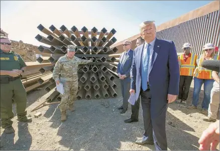  ?? John Gibbins San Diego Union-Tribune ?? PRESIDENT TRUMP tours a newly constructe­d section of replacemen­t border fence in San Diego on Wednesday. The $147-million project replaced a shorter, decades-old barrier with 14 miles of 18-foot-tall steel beams that the president called nearly impenetrab­le.