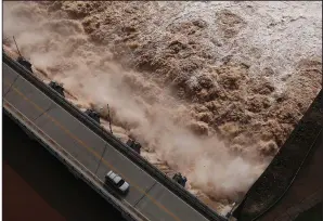  ?? AP/Tulsa World/TOM GILBERT ?? Excess water pours out of the dam on Keystone Lake northwest of Tulsa on May 24. The U.S. Army Corps of Engineers released millions of gallons of water from rain-swollen Oklahoma reservoirs into the Arkansas River, causing severe flooding in Arkansas. Gov. Asa Hutchinson is calling for a review of how the release was handled.