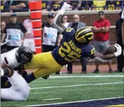  ?? PAUL SANCYA — THE ASSOCIATED PRESS ?? Michigan running back Hassan Haskins, right, dives into the end zone for a five-yard touchdown run against Northern Illinois in the first half of Saturday’s game in Ann Arbor.