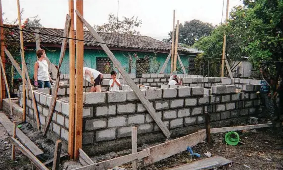  ?? Associated Press file photo ?? Volunteers help build a home in Siguatepeq­ue, Honduras. Using time off to help others makes for a meaningful holiday.