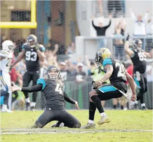  ?? PHELAN M. EBENHACK/ASSOCIATED PRESS ?? K Josh Lambo (4) celebrates after his game-winning field goal Sunday lifted teammate Jalen Ramsey (20) and the rest of the Jaguars past the Chargers — the team that had released Lambo earlier this season.