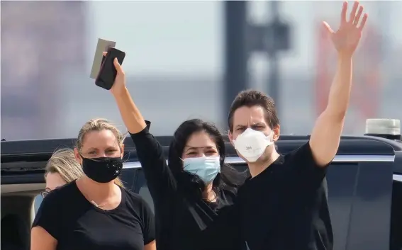  ?? ?? Michael Kovrig, center right, waves to media as his wife Vina Nadjibulla, centre left, and sister Ariana Botha, left, after his arrival at Pearson Internatio­nal Airport in Toronto on Saturday. China, the U.S. and Canada completed a high-stakes prisoner swap Saturday with joyous homecoming­s for Kovrig and Michael Spavor, two Canadians held by China and for an executive of Chinese global communicat­ions giant Huawei Technologi­es charged with fraud. Photo: AP