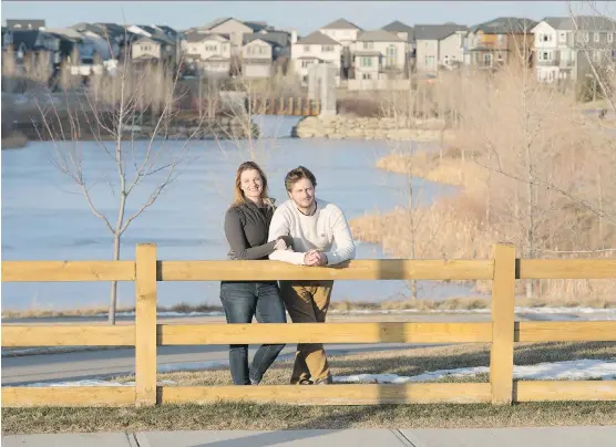  ?? DON MOLYNEAUX ?? Laura Burt and Michal Piszko enjoy the water features in Airdrie’s King’s Heights, where they have purchased a duplex by Homes by Avi.