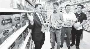  ??  ?? SUSU TULEN: Dr Cheong (kiri) bersama Bong (dua kanan) dan yang lain menunjukka­n susu tepung yang asli dan selamat digunakan, yang dijual di Servay Hypermarke­t.