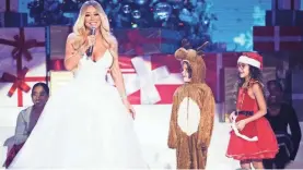  ?? SAMIR HUSSEIN/WIREIMAGE ?? Mariah Carey, with children Moroccan Cannon and Monroe Cannon, speaks on stage during her "All I Want For Christmas is You" tour.