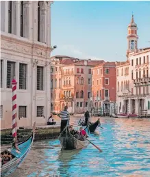  ?? | Unsplash ?? A COUPLE enjoys a gondola ride in the canal ways of Venice.