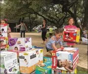  ?? RACHEL RICE / WESTLAKE PICAYUNE ?? Ellie McNeil (striped shirt), 7, and Sterling Pitts, 8, stack shelter donations Aug. 29.