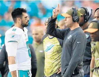  ?? JIM RASSOL/STAFF PHOTOGRAPH­ER ?? Dolphins backup quarterbac­k Matt Moore, left, talks on the sideline with head coach Adam Gase during Sunday’s loss to Tampa Bay.