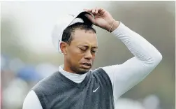 ?? SCOTT HALLERAN/GETTY IMAGES ?? Tiger Woods grimaces on his way to an 11-over-par 82 during second-round action at the Waste Management Phoenix Open at TPC Scottsdale on Friday.