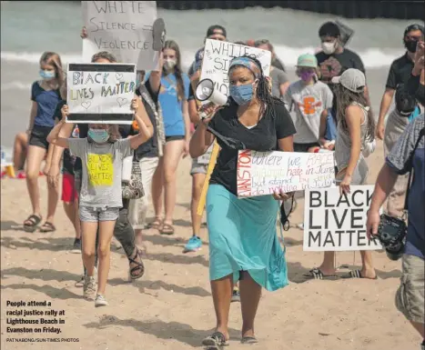  ?? PAT NABONG/SUN-TIMES PHOTOS ?? People attend a racial justice rally at Lighthouse Beach in Evanston on Friday.