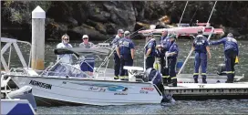  ?? MICK TSIKAS / AAP IMAGES ?? Fire & Rescue NSW personnel are seen at a boat ramp near Bobbin Head, New South Wales, on Tuesday. An accident investigat­or says the wreckage of a seaplane that crashed in a river north of Sydney will be raised this week.