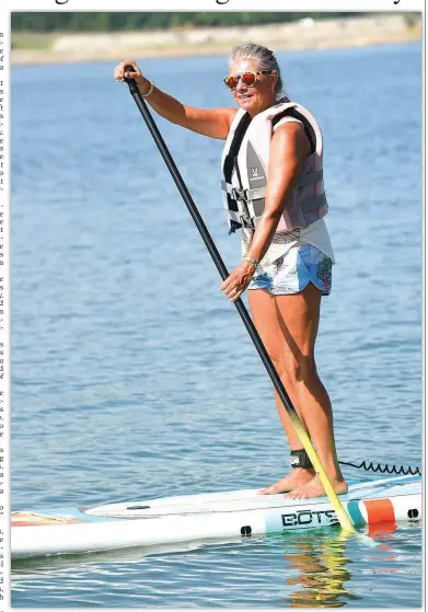  ?? NWA Democrat-Gazette/FLIP PUTTHOFF ?? Melody Elliott glides across Beaver Lake in July on her stand-up paddle board. The sport “gets you out in nature. You feel good when you’re on a body of water,” she said.