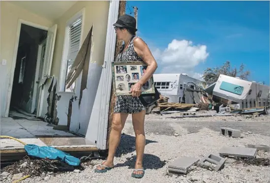  ?? Photograph­s by Marcus Yam Los Angeles Times ?? LAURA COSTELLO examines her hurricane-ravaged home in Islamorada, Fla. She’d moved in just a month ago. “I have my health, I have my life. I’m fine,” she said.