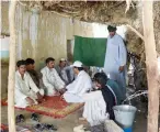  ?? AFP ?? People sit in a makeshift hut made of scrub bushes during a hot day in Sibi; and, right, a motorcycli­st drives through a closed market in Sibi. —