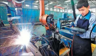  ?? SI WEI / FOR CHINA DAILY ?? A skilled worker operates a welding robot at an elevator-manufactur­ing company in Lianyungan­g, Jiangsu province.