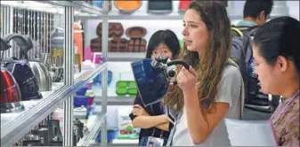  ?? XINHUA ?? A visitor purchases kettles at the 122nd Canton Fair, which concluded in Guangzhou on Nov 4.