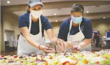  ?? DAX MELMER ?? Lisa Liovas, left, and Sherrie Koutsonico­las prepare salads for the Carrousel of Nations at the Hellenic Cultural Centre on Saturday.