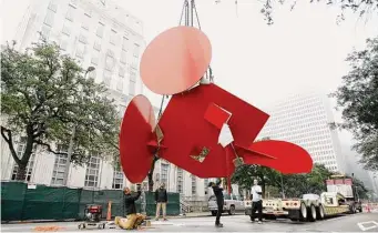  ?? Karen Warren / Staff photograph­er ?? Workers stabilize Houston’s iconic “Geometric Mouse, Scale X” sculpture by Claes Oldenburg during its move to the plaza of the Houston Public Library.