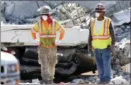  ?? THE ASSOCIATED PRESS ?? Workers stand in front of crushed cars under a section of a collapsed pedestrian bridge Friday near Florida Internatio­nal University in the Miami area.