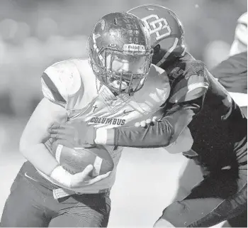  ?? MICHAEL LAUGHLIN/SUN SENTINEL PHOTOS ?? Miami Columbus running back Nicholas Maza is tackled by Deerfield Beach safety Tyron Herring on Friday.