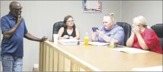  ?? Brodie Johnson • Times-Herald ?? Palestine City Council members Michelle Lawson, center, and Michelle Garner, right, look at pictures of property owned by Samuel Thomas, left, that was discussed during a public hearing at Tuesday’s council meeting. Palestine City Clerk Valerie Parker is also pictured.