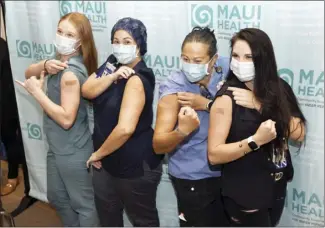  ?? The Maui News / MATTHEW THAYER photos ?? Maui Health System nurses Sloan Ponte (from left), Taryn Pacheco, Kiki Quarry and Katie Talbot flex for the cameras after being four of the first frontline staffers vaccinated for COVID-19 on Wednesday morning at the hospital.