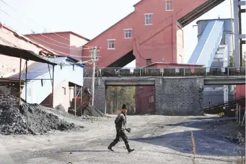  ??  ?? A miner walks at a coal mine from the state-owned Longmay Group on the outskirts of Jixi, in Heilongjia­ng province. After protests by unpaid coal miners made headlines around the world last year as China’s parliament was meeting, a US$15 billion...