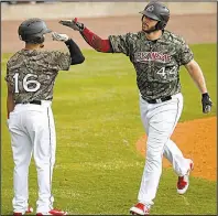  ?? Arkansas Democrat-Gazette/THOMAS METTHE ?? The Arkansas Travelers’ Joey Curletta (right) is congratula­ted by teammate Chris Mariscal after Curletta’s two-run home run in the fourth inning Sunday at Dickey-Stephens Park in North Little Rock. The Travelers won 3-1.