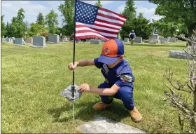  ?? PHOTO COURTESY OF CORY DERER ?? Scout Henry Balmer, 5, of Birdsboro, a member of Tiger Cub Scout Pack 595, places an American flag at a veteran’s grave at St. Michael’s Cemetery in Birdsboro on May 21in preparatio­n for Memorial Day.