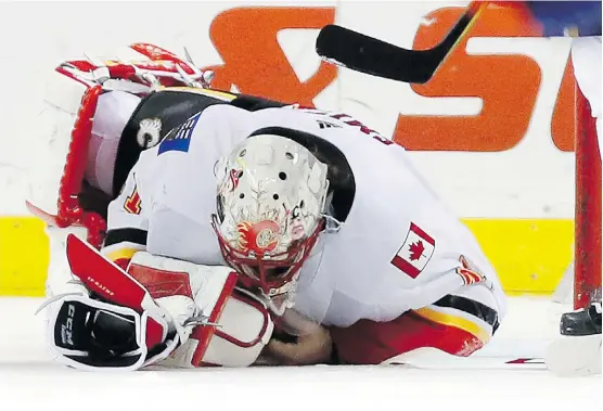  ?? KATHY WILLENS/THE ASSOCIATED PRESS FILES ?? Goaltender Mike Smith rolls over on the ice with just over a second left in a game against the New York Islanders on Feb. 11 in New York. The Flames won 3-2, but lost Smith and four of the next five games, including a 5-2 defeat in Boston that captain...