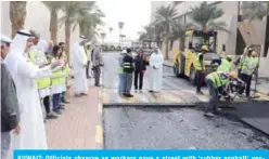  ??  ?? KUWAIT: Officials observe as workers pave a street with ‘rubber asphalt’ yesterday. — KUNA photo