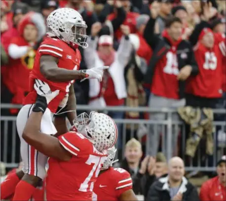  ?? JAY LAPRETE — THE ASSOCIATED PRESS ?? Ohio State receiver Johnnie Dixon, top, celebrates his touchdown against Michigan during the first half of an NCAA college football game Saturday in Columbus, Ohio.