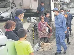  ?? AFP ?? Prime Minister Shinzo Abe, right, speaks with residents as he visits a flood-hit area in the village of Kuma in Kumamoto prefecture yesterday.