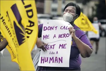  ?? Jessica Hill Associated Press ?? HEALTHCARE workers march outside the Capitol in Hartford, Conn., during a July 2020 protest. A year and a half into the pandemic, the topic of “hero pay” has political implicatio­ns for some leaders and unions.