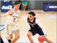  ?? Matt Slocum / Associated Press ?? UConn’s James Bouknight, right, dribbles past Villanova’s Collin Gillespie during the second half on Saturday in Villanova, Pa.