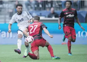  ?? — THE CANADIAN PRESS ?? Whitecaps’ Giles Barnes, left, puts the ball past Portland Timbers’ Steven Taylor as Alvas Powell watches.